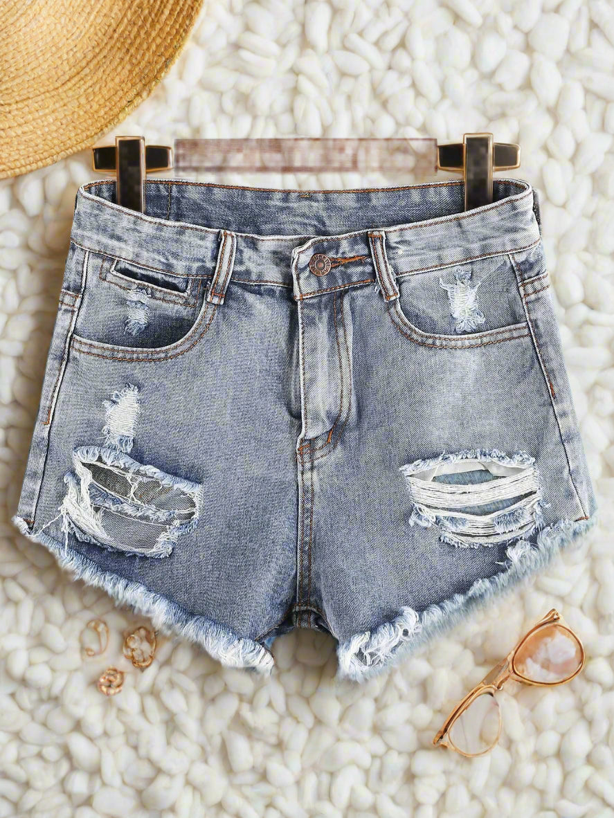 Light blue distressed frayed jean shorts with a raw hem, displayed on a hanger.